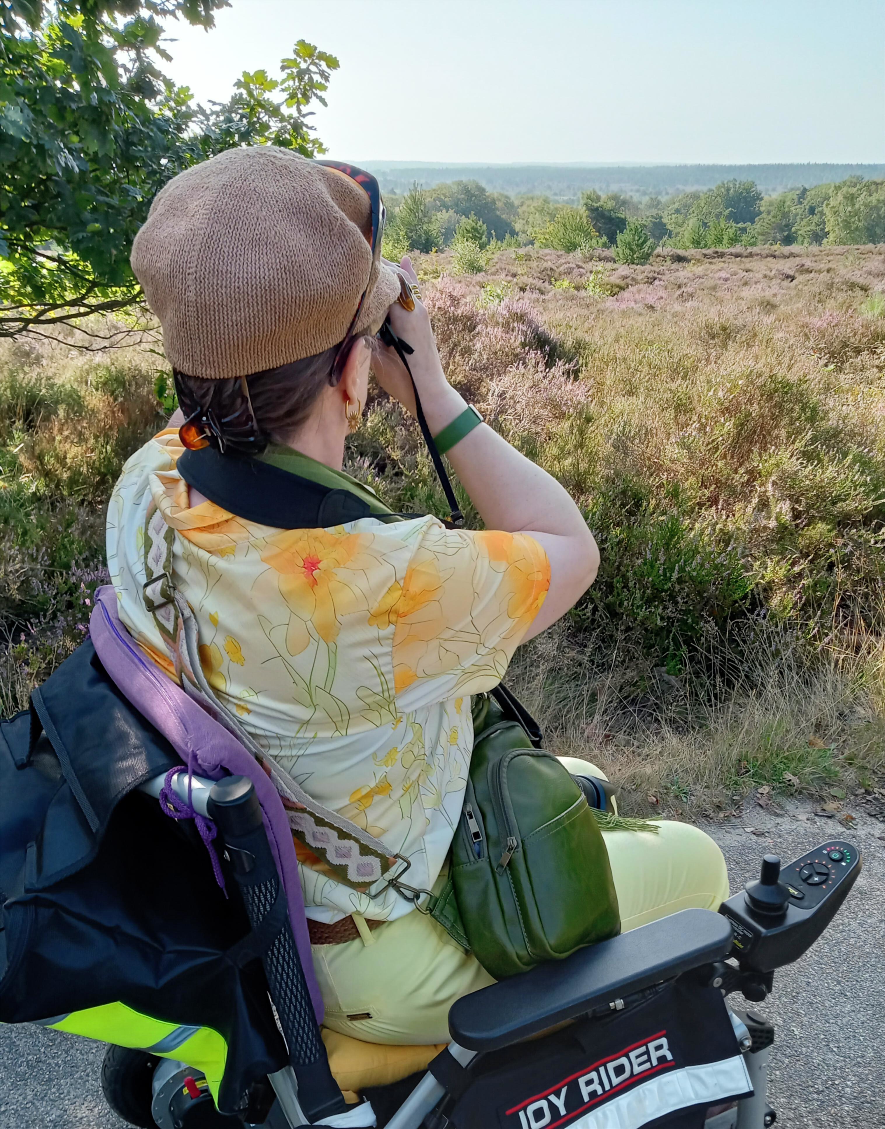 Foto: vrouw in rolstoel fotografeert de heide.