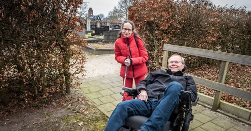 Foto: Jacob Mulder in zijn elektrische rolstoel in een natuurgebied samen met een vrouw met een visuele beperking